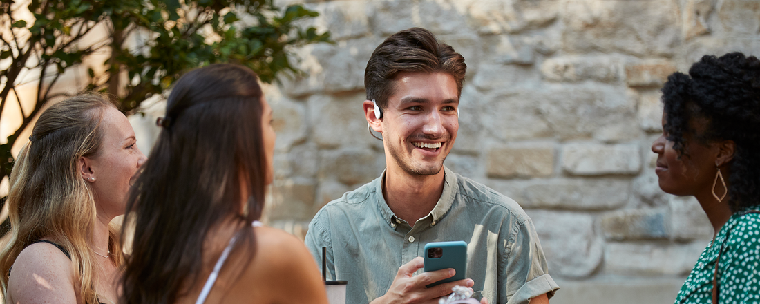 Group of friends talking while wearing AfterShokz headphones