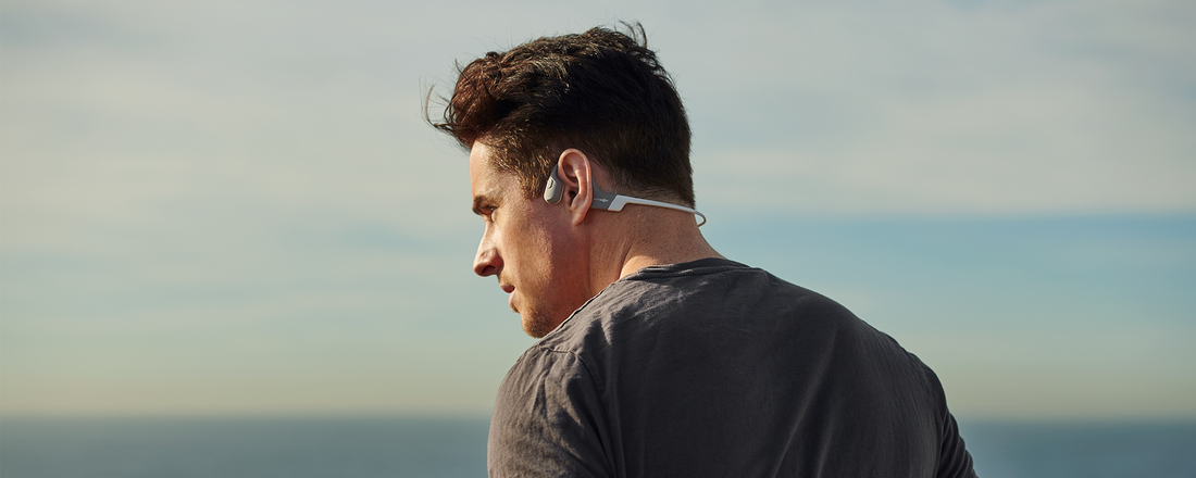 Man running outdoors while wearing AfterShokz Aeropex wireless headphones