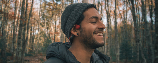 Man outside in forest wearing AfterShokz Air headphones 