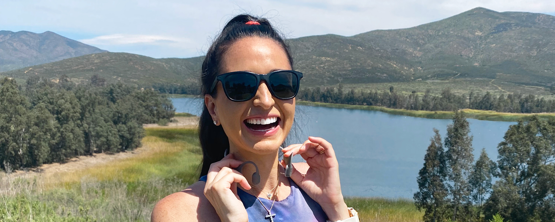Image of running coach Kim Clark outside wearing Shokz OpenRun wireless headphones