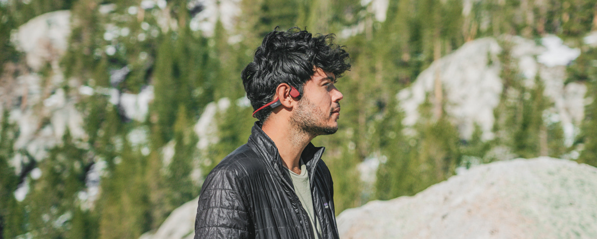 Man hiking in park wearing AfterShokz Air wireless headphones
