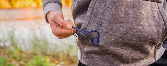 Person holding AfterShokz Air headphones