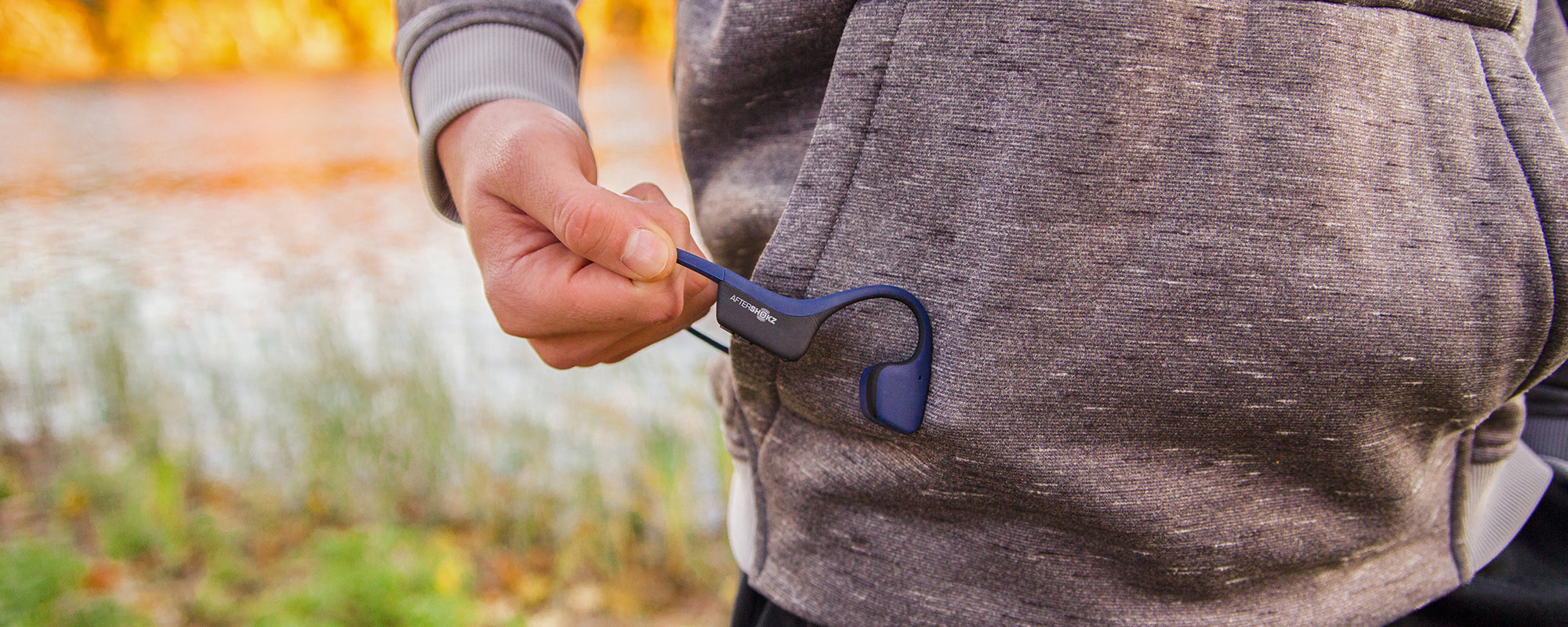 Person holding AfterShokz Air headphones