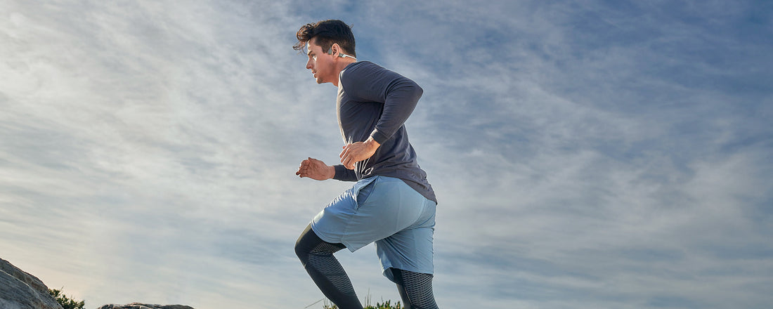Man running outdoors wearing AfterShokz Aeropex headphones