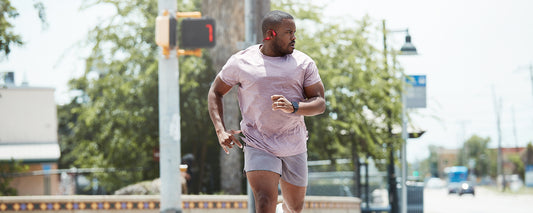 Man running in the city wearing AfterShokz Aeropex headphones
