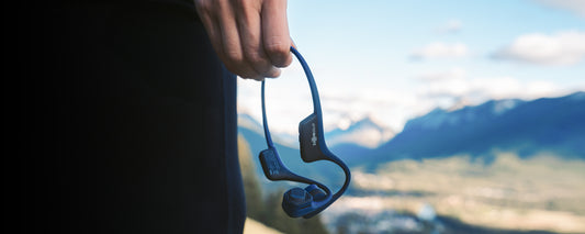 Person holding AfterShokz Air wireless headphones