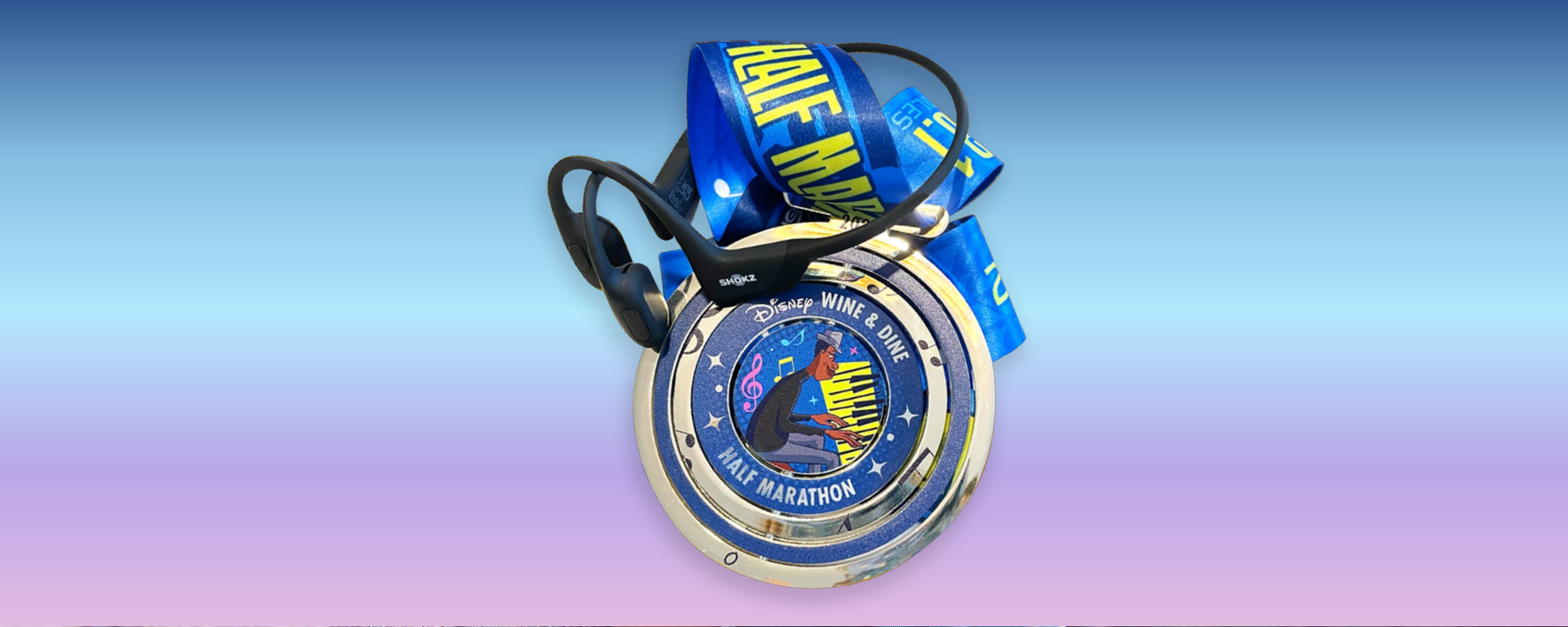 Close up image of the Half Marathon medal and black Shokz OpenRun Pro headphones