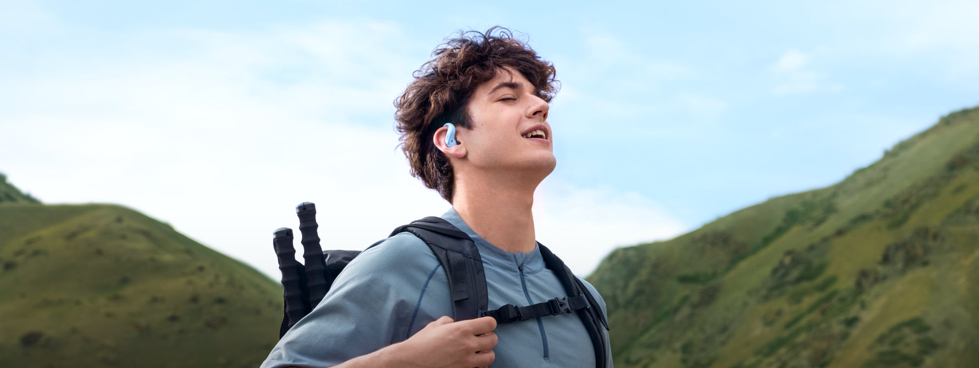 A Hiker Wearing Shokz OpenFit Air 2 Open-ear Headphones Built for Motion, Featuring A Skin-friendly Design.