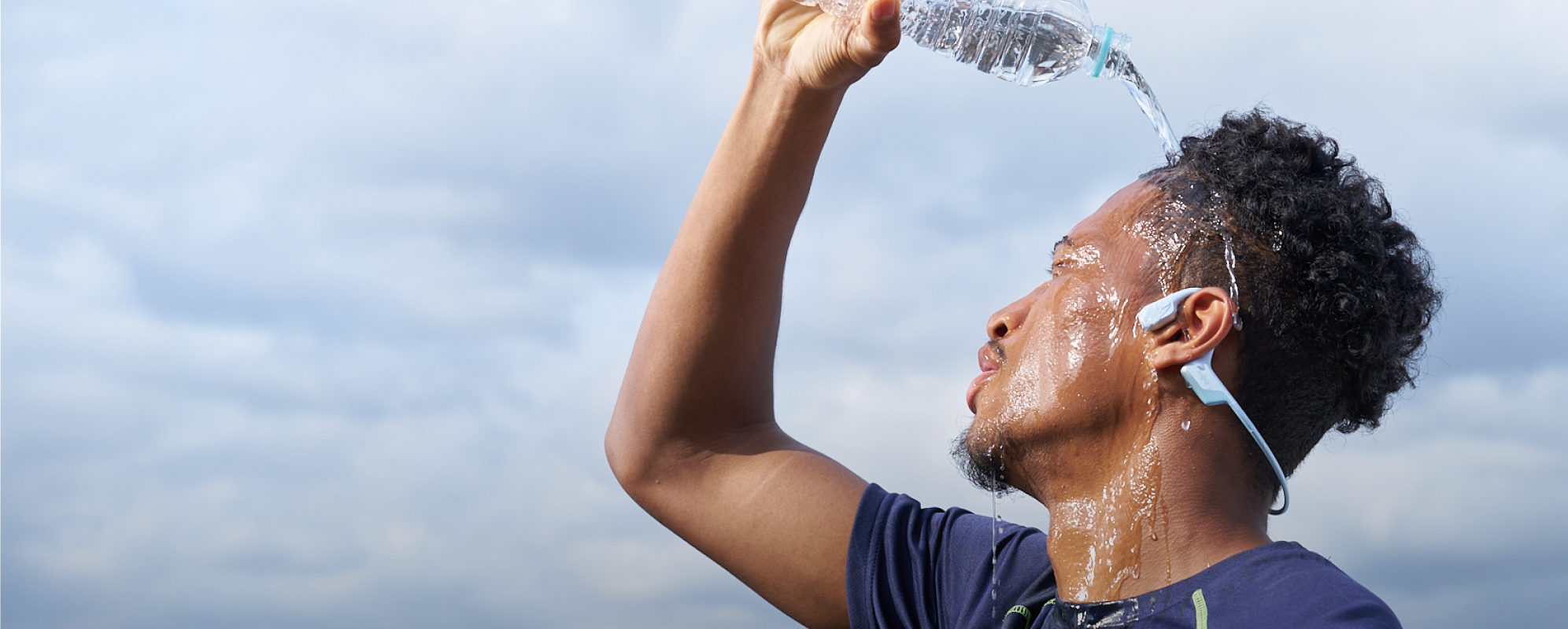 Person pouring water while wearing OpenRun Air 2
